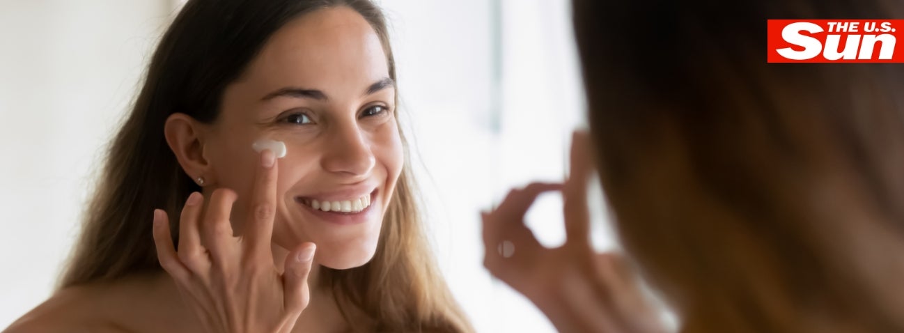 Woman smiling and putting Neora’s Day Cream on her face