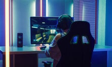 woman on computer playing video games with colorful LED lighting