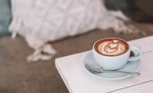 A cappuccino in a round mug on a table.