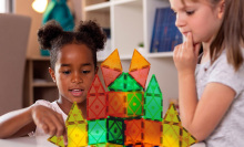 two children playing with magnetic blocks