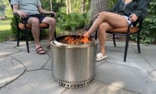 two people sitting around a solo stove bonfire 2.0 on a stone patio