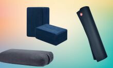 Manduka yoga bolster, yoga blocks, and yoga mat on abstract background