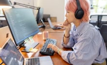 woman coding with headphones on