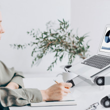 Person using laptop on a silver and black stand