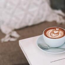 A cappuccino in a round mug on a table.