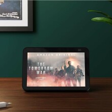 an amazon echo show sits on a tabletop showing a movie title screen