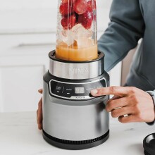 Man presses button on Ninja personal blender 