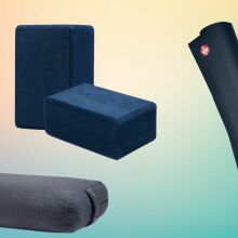 Manduka yoga bolster, yoga blocks, and yoga mat on abstract background