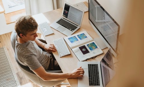 Man sat at desk with papers and laptop