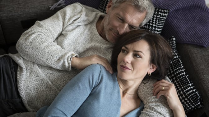 An older couple cuddling on the couch