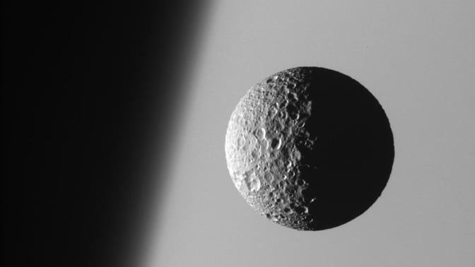 Mimas moon orbiting Saturn