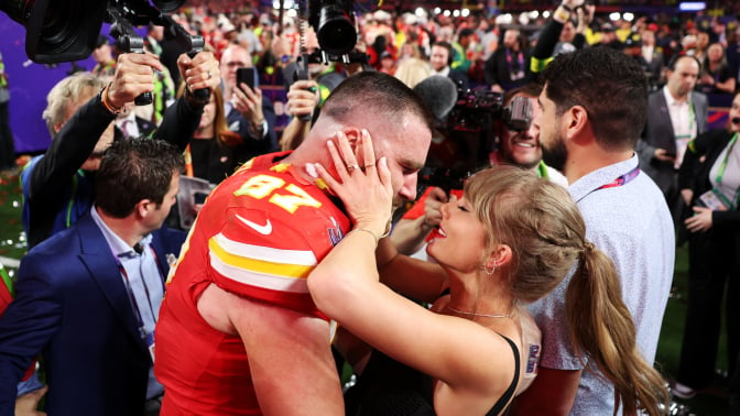 Travis Kelce and Taylor Swift celebrating on the field after the Super Bowl.