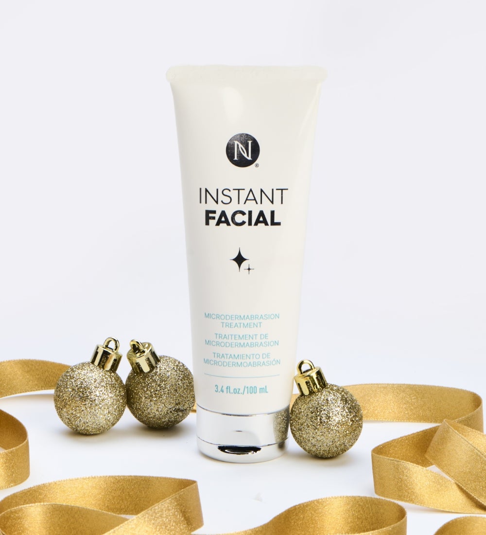 New! A Facial Treatment Tube is surrounded by festive, gold ribbon and ornaments.