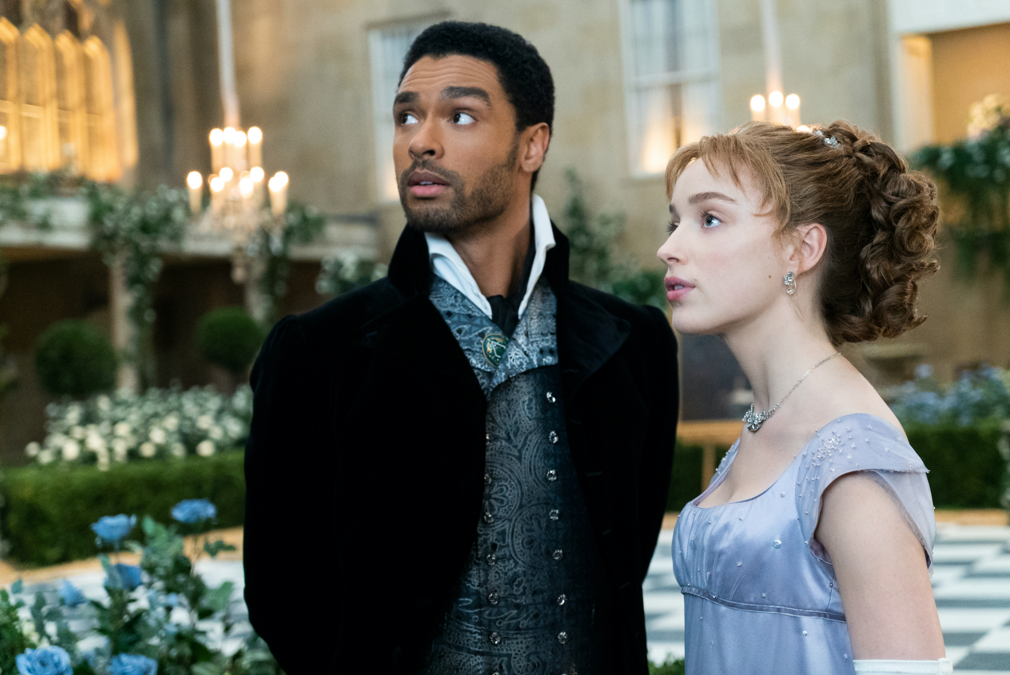 A scene from "Bridgerton": man and woman in period clothing stand looking off camera