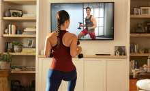 woman standing in front of a TV playing a workout video