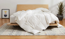 White duvet cover on a bed with a wooden bed frame