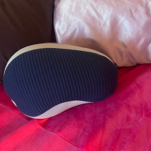 bean shaped pillow on pink bedspread