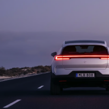 Polestar SUV driving on road beside body of water