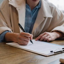 person writing on resume at desk