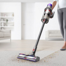 woman vacuuming rug with dyson outsize plus